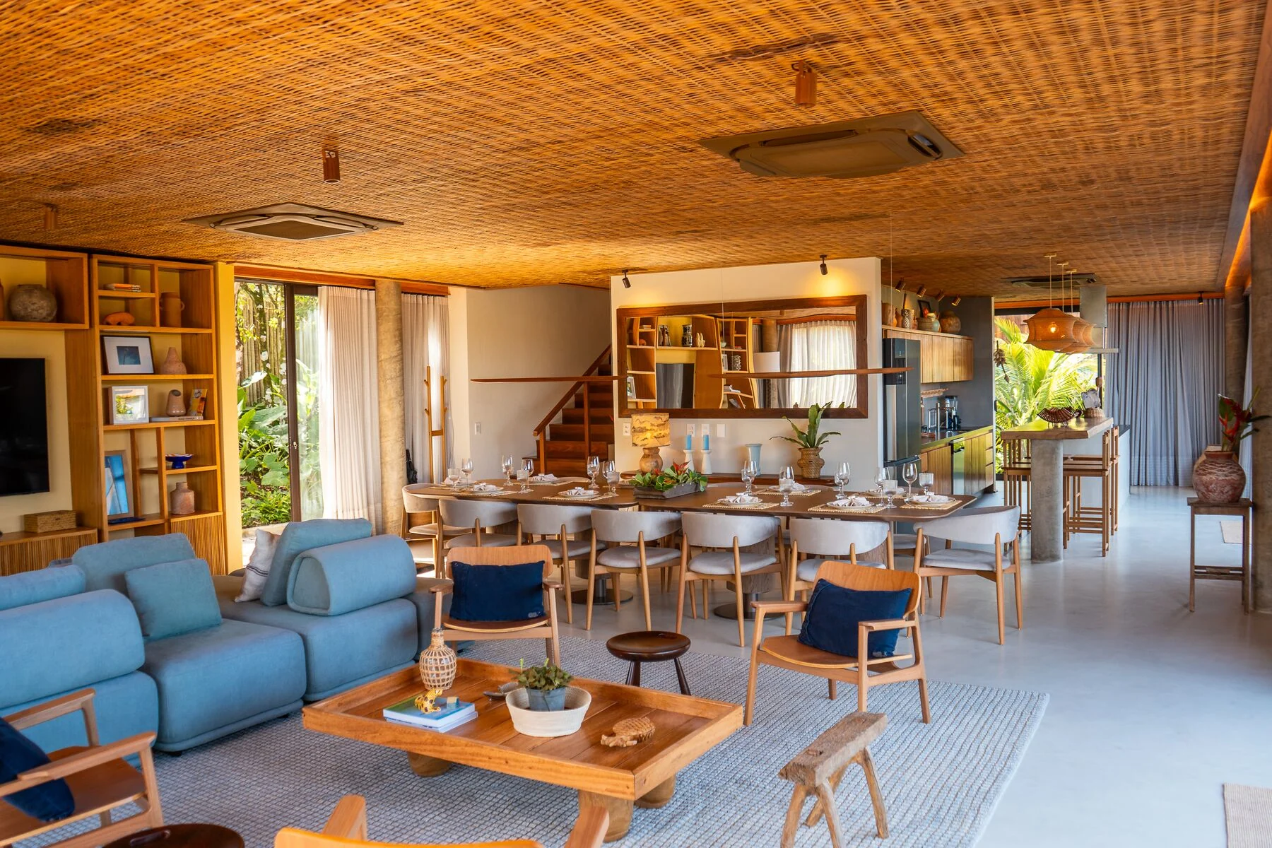 Sala e jantar amplos da Casa 201 com sofá azul